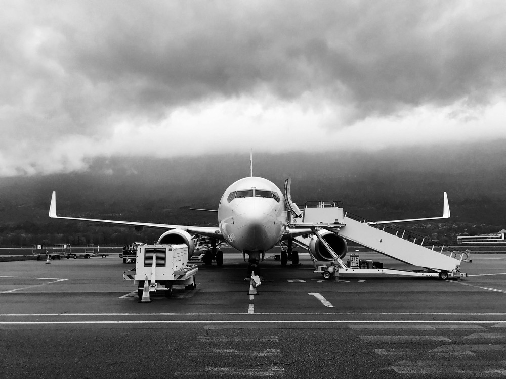 Aircraft on the tarmac under a heavy sky, in black and white