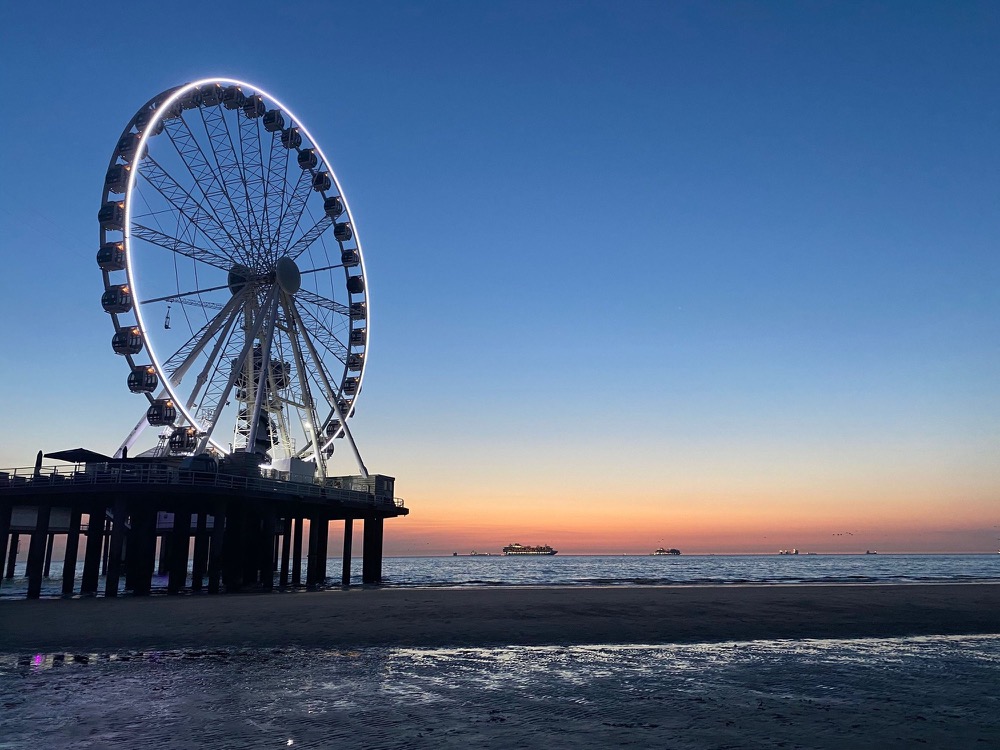 Pier with a ferris wheel at sunset